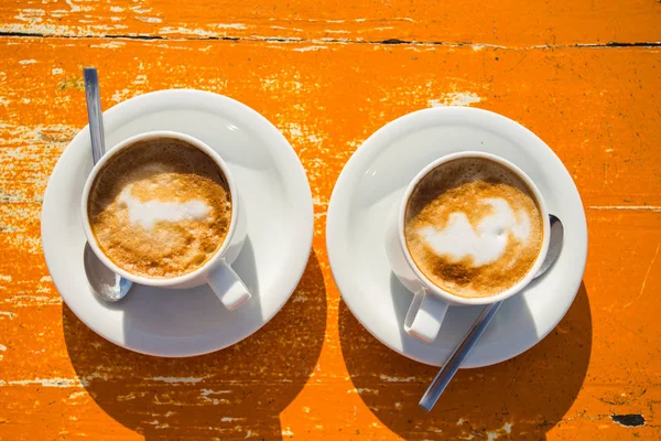 Dois cappuccinos revigorantes na mesa esperam por você — Fotografia de Stock