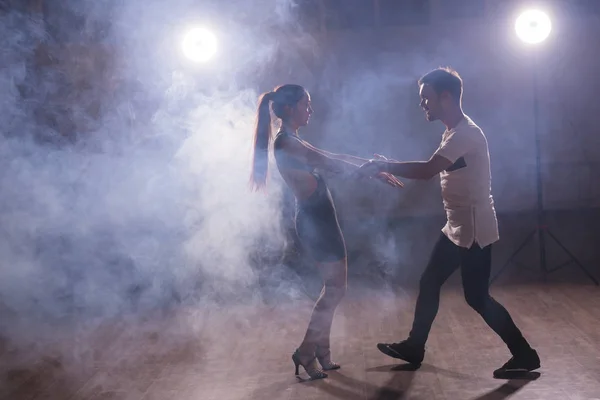 Pareja joven bailando baile latino Bachata, merengue, salsa. Dos poses de elegancia en clase de baile — Foto de Stock