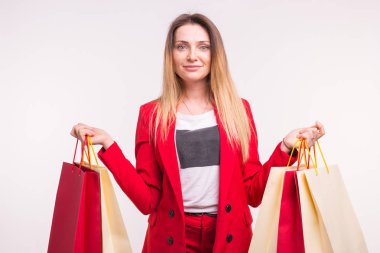 Kırmızı elbiseli alışveriş torbaları ile mutlu şık genç kadın portresi