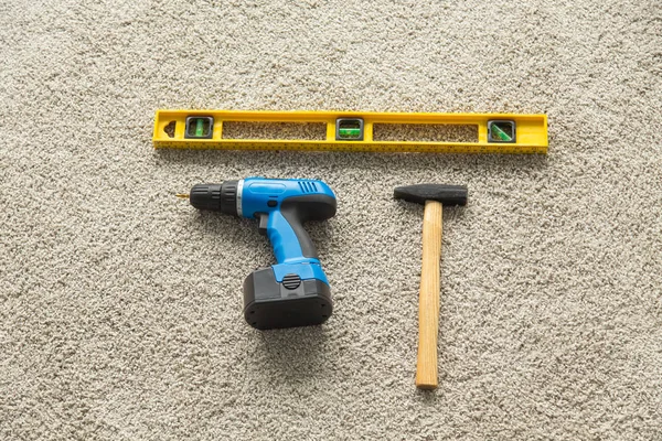 İnşaat kavramı - çekiç, matkap ve inşaatçılar düzeyi yerdeki, üstten görünüm