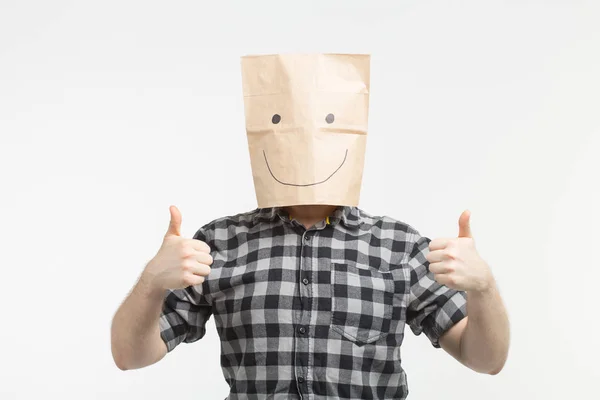 Hombres en la máscara de bolsa de papel feliz con pulgares hacia arriba sobre fondo blanco — Foto de Stock