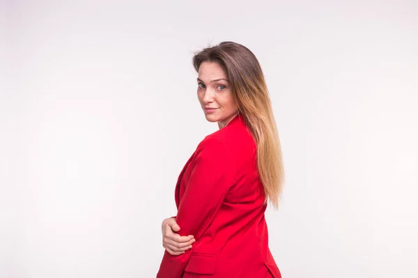 Porträt einer jungen Frau im roten Anzug, die auf weißem Hintergrund mit Kopierraum posiert — Stockfoto