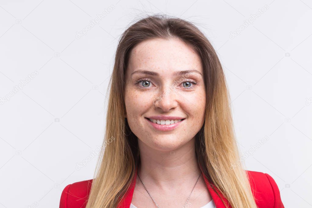 Portrait of smiling freckled beautiful woman wearing red suit