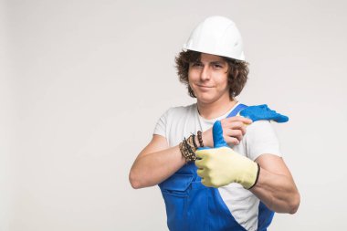 Beyaz kask ve mavi tulum başparmak yukarıya ile bir üreticisi portresi.