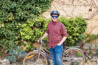 Mutlu genç erkek tutun Bisiklet arka plan yeşil