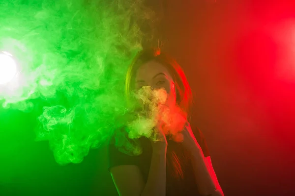 Retrato de niña en humo de neón de color con vapor o cigarrillo electrónico . — Foto de Stock