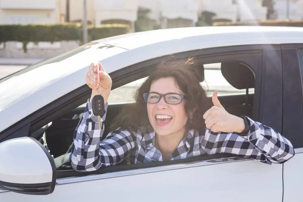 Başparmak yukarıya ve anahtar arabada genç kadın gösterir