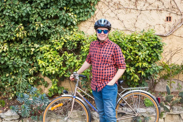 Mutlu genç erkek tutun Bisiklet arka plan yeşil