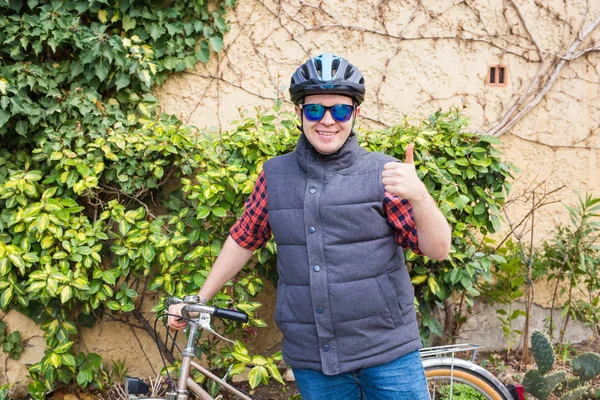 Başparmak parkta güneşli günde gösterilmesini bisiklet ile yakışıklı genç