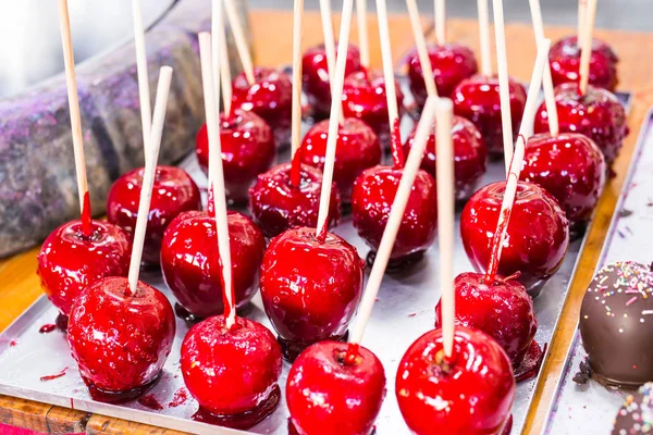 Karamel yum yum bir sopa üzerinde kırmızı elmalar