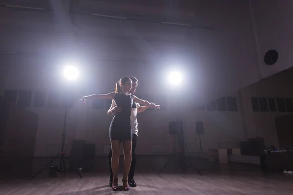 Dançarinos habilidosos se apresentando na sala escura sob a luz do concerto e fumaça. Casal sensual realizando uma dança contemporânea artística e emocional — Fotografia de Stock