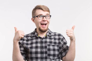 Kareli gömlek giymiş yukarı başparmak ile gözlüklü genç komik adam portresi
