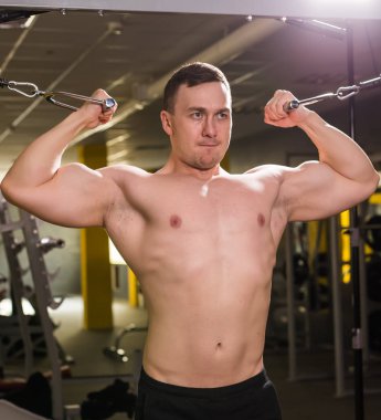 Güçlü kas vücut geliştirmeci spor salonunda egzersiz yapmak. Fitness eğitimi
