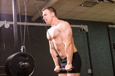 Güçlü kas vücut geliştirmeci spor salonunda egzersiz yapmak. Fitness eğitimi