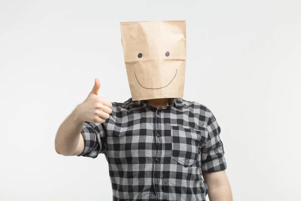 Homens em máscara saco de papel feliz com polegares para cima no fundo branco — Fotografia de Stock
