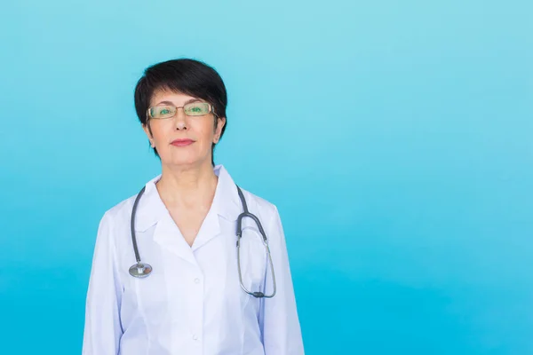 Γιατρός γυναίκα χαμόγελο πρόσωπο με στηθοσκόπιο σε μπλε φόντο με αντίγραφο χώρου — Φωτογραφία Αρχείου