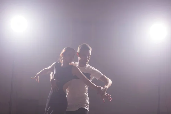 Pareja joven bailando baile latino Bachata, merengue, salsa. Dos poses de elegancia en clase de baile — Foto de Stock