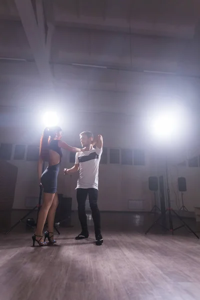 Pareja joven bailando baile latino Bachata, merengue, salsa. Dos poses de elegancia en clase de baile — Foto de Stock