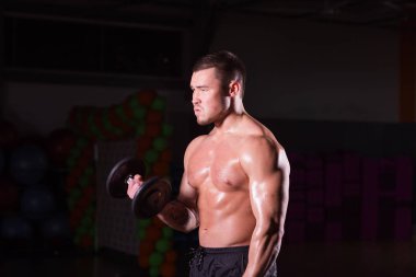 kas genç adam koyu arka plan üzerinde ağırlık kaldırma