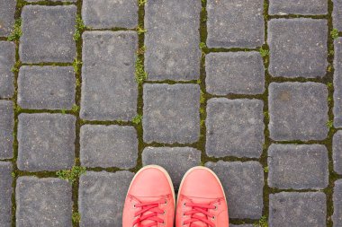 Kırmızı spor ayakkabılar parke taşlar üzerinde