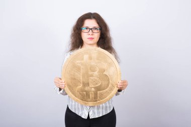 Büyük altın bitcoin - kripto para birimi, web blockchain ve para kavramı tutan ciddi genç kadın