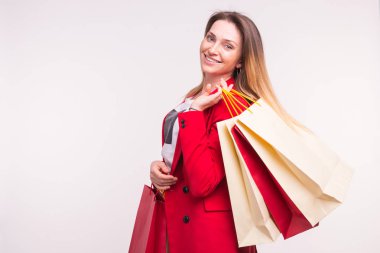 Sırtındaki kopya alanı ile alışveriş torbaları ile kırmızı ceketli güzel kadın portresi