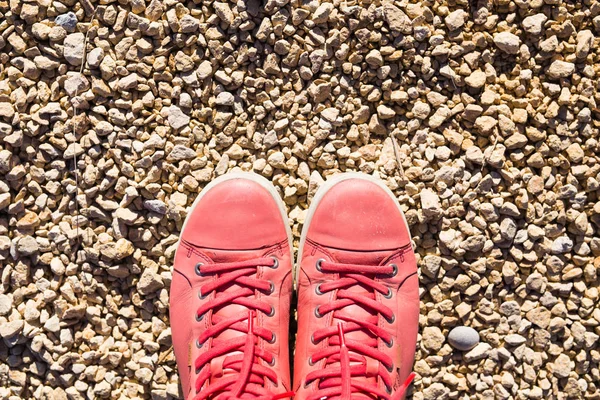 Röda sneakers på torr mark. På stenläggningen är röda sneakers — Stockfoto