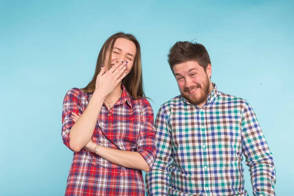 Engraçado jovem casal rindo e brincando juntos no fundo azul . — Fotografia de Stock