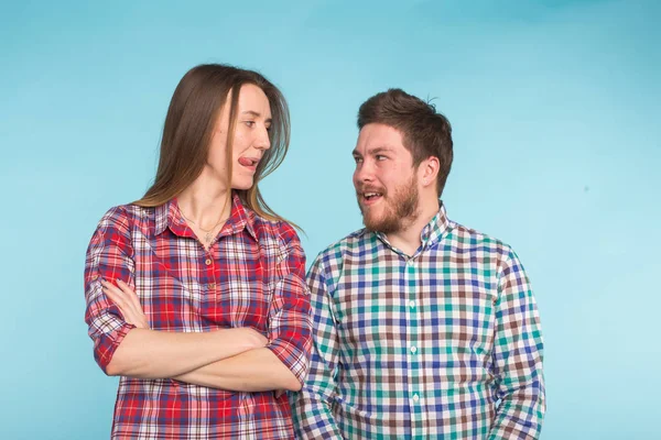 Engraçado jovem casal rindo e brincando juntos no fundo azul . — Fotografia de Stock