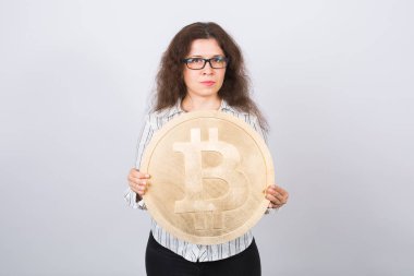 Büyük altın bitcoin - kripto para birimi, web blockchain ve para kavramı tutan ciddi genç kadın