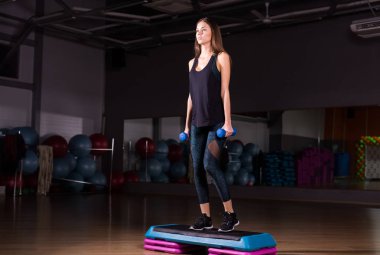 Spor salonunda adım platformda sportif kadın uygulama