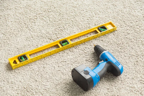Builders level and drill on the floor, top view — Stock Photo, Image
