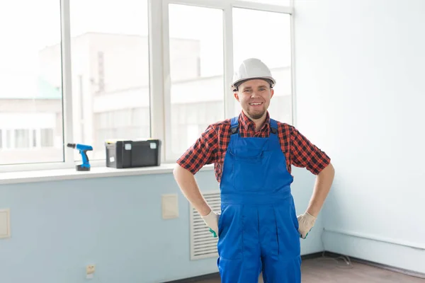 Happy white male builder in front of window with drill and toolbox. — Stock Photo, Image