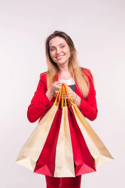 Retrato de mujer joven con estilo feliz con bolsas de compras en traje rojo — Foto de Stock