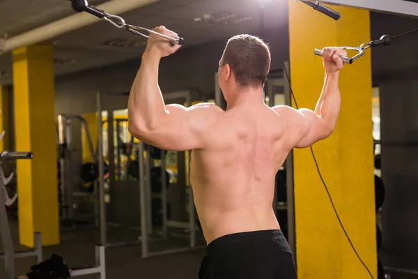 Zadní pohled na silné svalnaté kulturista dělat cvičení v tělocvičně. Fitness trénink — Stock fotografie