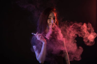 Asyalı kadın sigara vape veya e-sigara neon ışık siyah arka plan, portre.