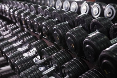 Siyah dumbbell spor fitness merkezinde ayarlayın. Ağırlık antrenmanı ekipmanı kavramı.