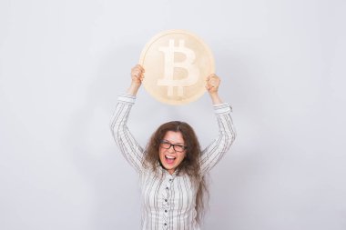 Cryptocurrency, sanal para ve blockchain kavramı - genç komik kadın büyük bir altın bitcoin elinde tutar..