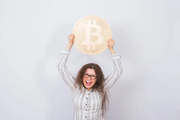 Criptomoneda, dinero virtual y blockchain concepto - Joven mujer divertida sostiene un gran bitcoin de oro en su mano . — Foto de Stock