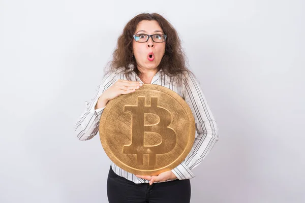 Criptomoneda, dinero virtual y concepto blockchain - retrato de empresaria sorprendida sosteniendo bitcoin grande sobre fondo blanco — Foto de Stock