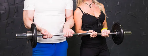 Sport, bodybuilding, lifestyle and people concept - Close up of man and woman with barbell
