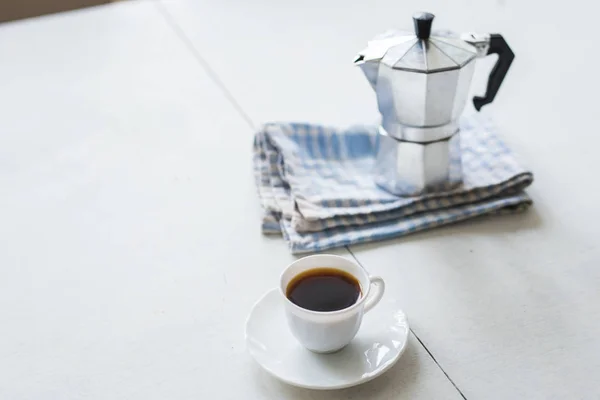 Xícara de café, chaleira de café em uma mesa branca — Fotografia de Stock