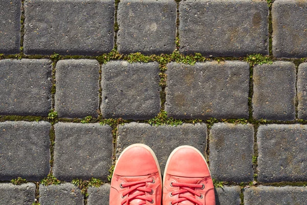 På stenläggningen är röda sneakers — Stockfoto