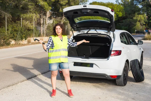 Rozbité auto. Mladá žena neví, jak změnit kolo — Stock fotografie