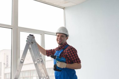 Merdivene tornavida ile pencerenin infront ayakta mutlu erkek Oluşturucu.