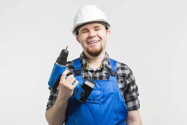 Close-up of handsome male builder with screwdriver wearing white helmet. — Stock Photo, Image