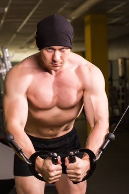 Spor salonunda egzersiz yapan kaslı bir adam. Güçlü erkek, çıplak karın kasları.