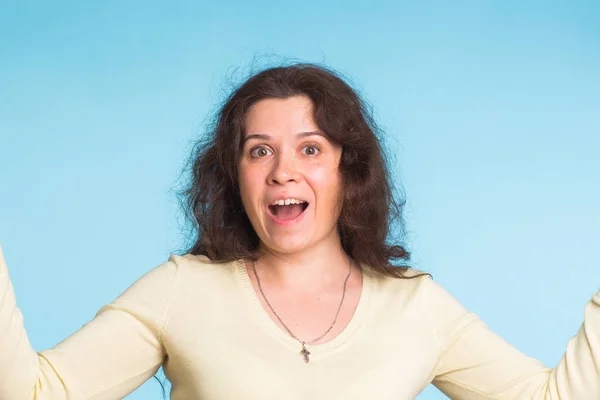 Jovem feliz com cabelo encaracolado no fundo azul — Fotografia de Stock