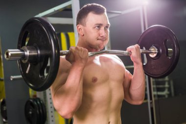 Yakışıklı güç halter atletik adamla. Altı paket, mükemmel abs, omuzlar, pazı, triceps ve göğüs ile güçlü vücut geliştirmeci
