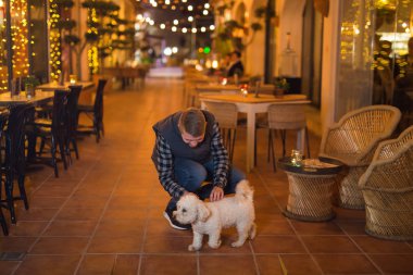 Evde beslenen hayvan sahibi ve insanlar kavramı - gece sokak köpeğiyle yürüyen genç adam.